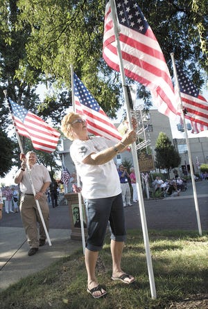 During the 2013 posting of Ohio Flags of Honor at Duncan Plaza, Gold Star Mother Patti Grass places the flag for her son Army Cpl. Zachary A. Grass, who was killed in action June 16, 2007.