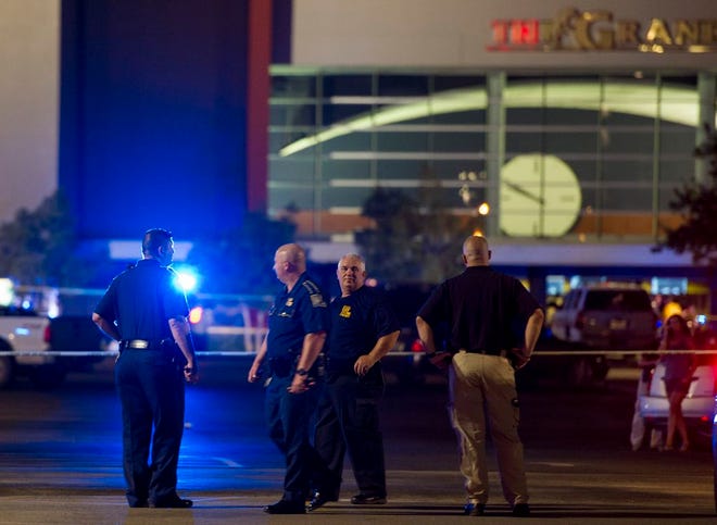 Law enforcement personnel stand near a police line at The Grand Theatre following a deadly shooting in Lafayette, La., Thursday, July 23, 2015. (Paul Kieu/The Daily Advertiser via AP)