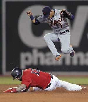 Tigers shortstop Jose Iglesias leaps over Mike Napoli, after making the force on a double play at Fenway Park. THE ASSOCIATED PRESS
