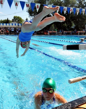 Woodstream's Gianna Antonelli, 12, jumps into the pool during the relay as Megan Zeiler, 11, comes in after her lap during the Burlington County Swim Championships at Woodstream Swim Club.