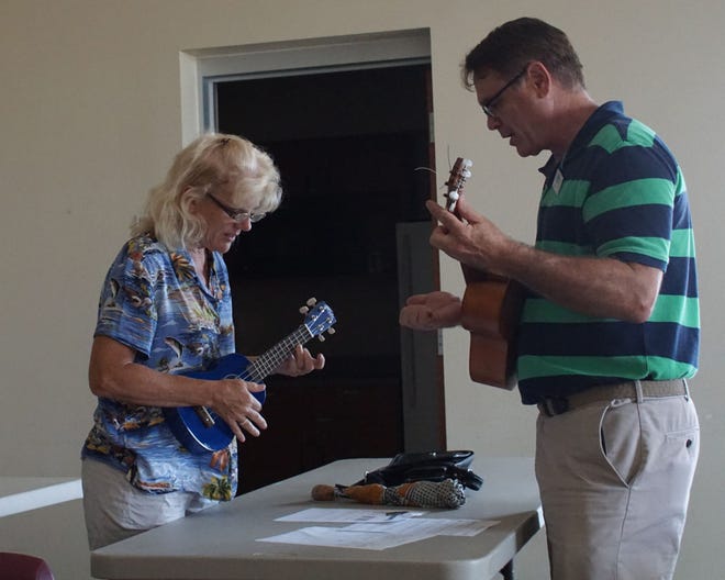 Teresa Foster takes her first ukulele lesson, compliments of ukulele club director Boyd Bruce.