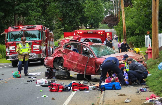 Firefighters work to help two people involved in a single-vehicle rollover crash on Sixth Street in Dover early Saturday afternoon. Photo by Shawn St.Hilaire/Fosters.com