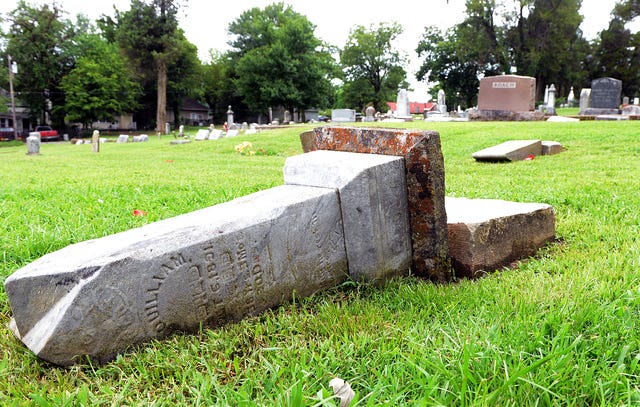 BRIAN D. SANDERFORD • TIMES RECORD A monument marking a grave from 1891 is seen toppled over on Tuesday, July 21, 2015 at Fairview Cemetery in Van Buren. Randy Smith, a volunteer at the cemetery said 35 monuments were vandalized over the weekend. Smith said the cemetery has been owned by the city of Van Buren since 1837, and that the earliest grave marker at Fairview is dated 1816.