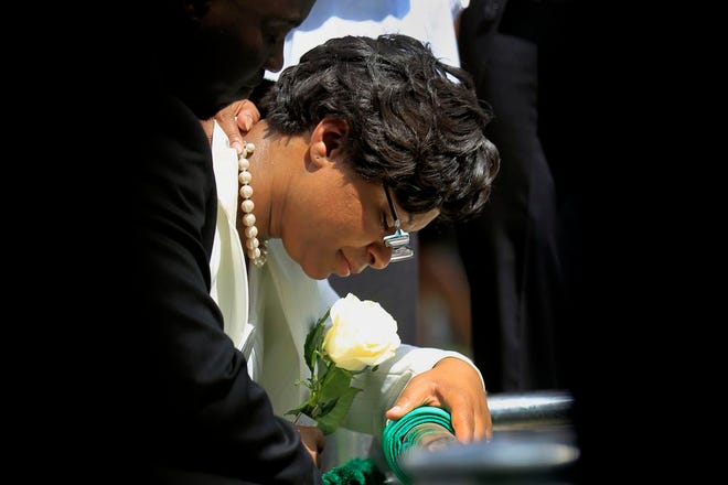 Sandra Bland's sister Sharon Cooper kneels at Bland's burial site at the Mt. Glenwood Memorial Gardens West cemetery Saturday, July 25, 2015, in Willow Springs, Ill. An autopsy report released Friday found that Sandra Bland used a plastic trash bag to hang herself three days after a confrontational traffic stop. The 28-year-old woman’s family has questioned the findings, saying she was excited about starting a new job and wouldn’t have taken her own life. (AP Photo/Christian K. Lee)
