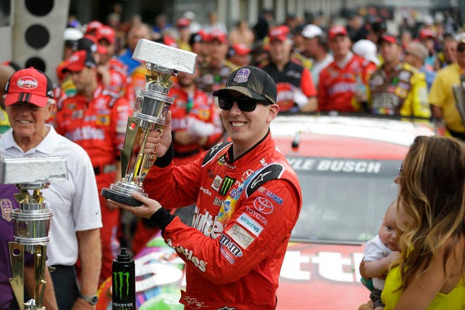 Sprint Cup Series driver Kyle Busch (18) celebrates after winning the NASCAR Brickyard 400 auto race at Indianapolis Motor Speedway in Indianapolis, Sunday, July 26, 2015. (AP Photo/Michael Conroy)