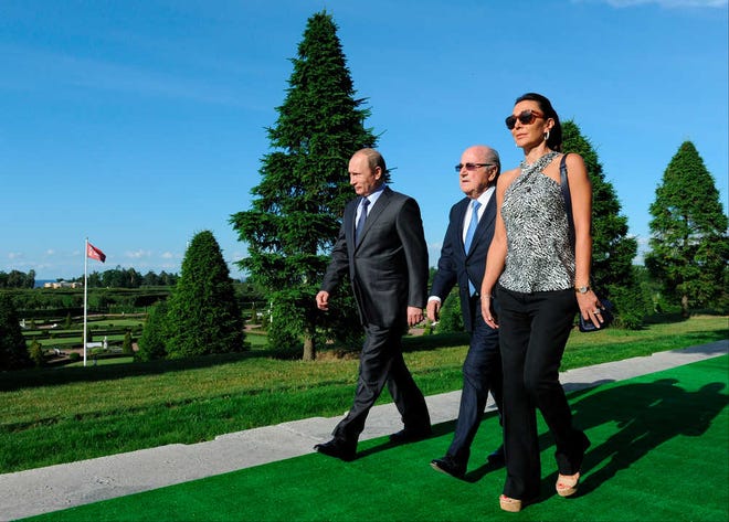 Russian President Vladimir Putin, left, and FIFA President Sepp Blatter with his partner Linda Barras walk before the 2018 World Cup preliminary draw in the Konstantin palace in St. Petersburg, Russia, on Saturday, July 25.