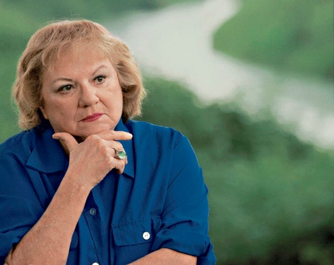 This July 2004 file photo shows, true-crime author Ann Rule, who wrote a book about serial killer Gary Ridgway, who left some of his victims' bodies along the Green River outside Seattle, Wash., shown in the background. Rule, who wrote more than 30 books, including a profile of her former co-worker, serial killer Ted Bundy, has died at age 83. Scott Thompson, a spokesman for CHI Franciscan Health, said Rule died at Highline Medical Center at 10:30 p.m. Sunday, July 26, 2015. (Betty Udesen/The Seattle Times via AP, File)