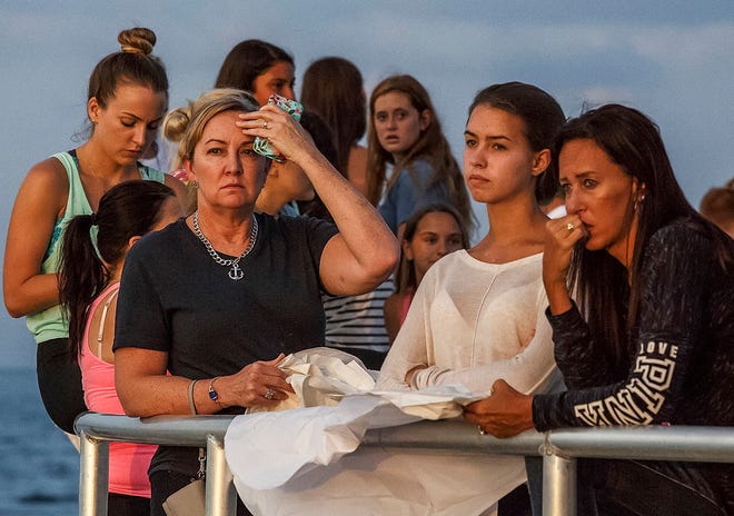 People gather during a candlelight vigil and paper balloon release at Jupiter Inlet Park, Monday, July 27, 2015, for teenagers Austin Stephanos and Perry Cohen in Jupiter, Fla. The teens were last seen Friday afternoon buying fuel near Jupiter and were believed to have been heading toward the Bahamas. (Thomas Cordy/The Palm Beach Post via AP)
