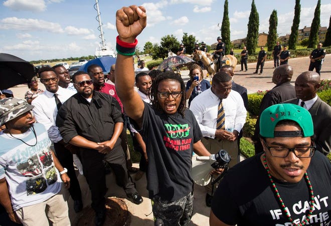Malik Muhammad raises his fist during a demonstration calling for the firing and indictment of Texas State Trooper Brian Encinia, Sunday, July 26, 2015, in Katy, Texas. Sandra Bland was found dead in her cell on July 13 in the Waller County Jail, just days after being arrested by Encinia during a traffic stop. Authorities determined through an autopsy that Bland hanged herself with a plastic bag. (Brett Coomer/Houston Chronicle via AP)