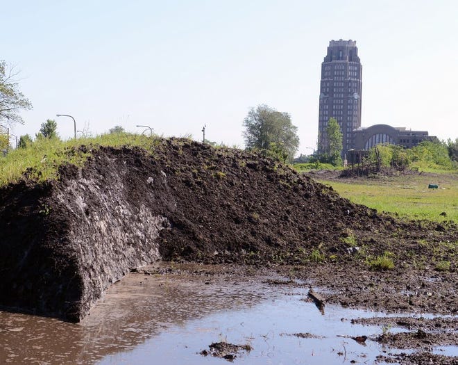 A dirt covered snow pack, dumped eight months ago, creates pools of water as it slowly melts around the abandoned train station vacant lot in Buffalo, N.Y., Tuesday, July 28, 2015. City crews dumped snow in the lots after a lake-effect storm dumped more than 7 feet on parts of Buffalo and the surrounding area last November. Eight months later, some of it is still there.