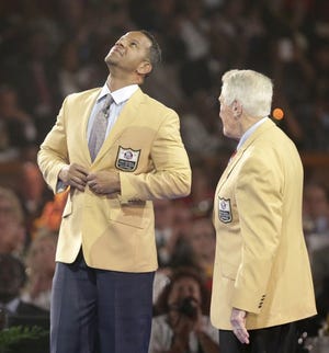 Andre Reed buttons his gold jacket as Marv Levy stands by at last year's ceremony.