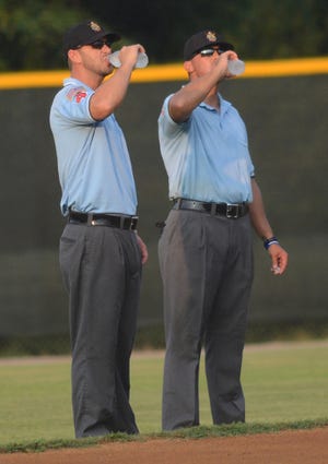 BRIAN D. SANDERFORD • TIMES RECORD Umpires Eric Prater, left, and Brandon Bennett cool off between innings on Monday evening, July 27, 2015 at the University of Arkansas at Fort Smith’s Crowder Field during the Arkansas American Legion State Tournament. Fort Smith was playing Bryant.