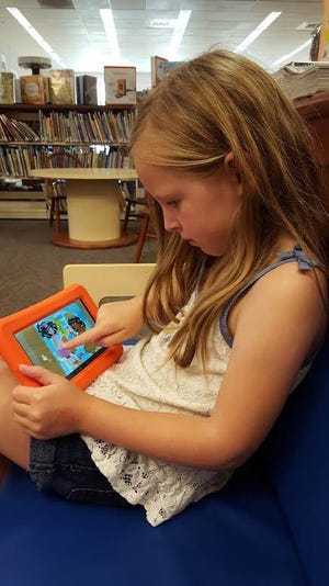 Evangeline Campbell, 5, plays with one of the 14 Launchpads that were recently purchased for patron use at the Fiske Public Library. CONTRIBUTED PHOTO/LIZ NADOW, FISKE CHILDREN'S LIBRARIAN