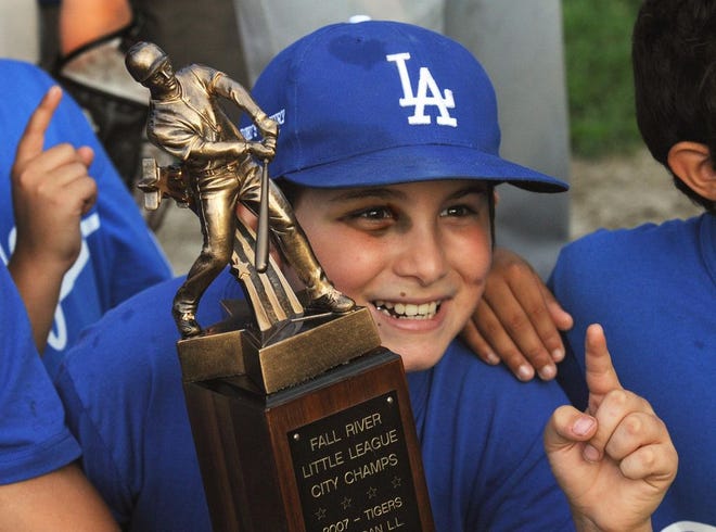 Dylon Teixeira, still sporting a shiner suffered in a previous game, poses with the Russ Gibson Trophy after helping the National Dodgers to the 2014 City Little League championship last August.