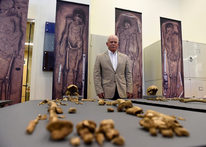 Bill Kelso, director of archaeology at Jamestown Discover, poses with bone fragments of four high-status leaders who helped shape the future of America during the initial phase of the Jamestown colony displayed at the Smithsonian's National Museum of Natural History in Washington, Tuesday, July 28, 2015. Archaeologists have uncovered human remains of four of the earliest leaders of the English colony that would become America, buried for more than 400 years near the altar of what was America's first Protestant church in Jamestown, Virginia. (AP Photo/Susan Walsh)