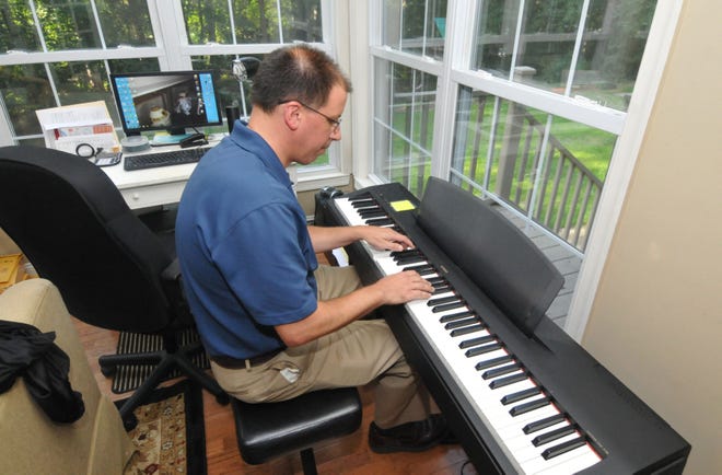 Pianist and composer Stephen Majewski of Medford plays piano at his home.