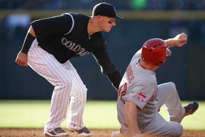 Colorado Rockies shortstop Troy Tulowitzki , left, tags out Cincinnati Reds' Jay Bruce as he tries to steal second base in the third inning of a baseball game Saturday, July 25, 2015, in Denver. (AP Photo/David Zalubowski)