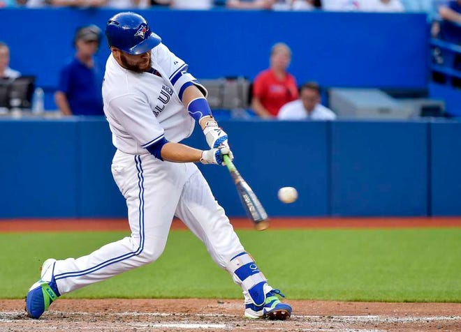 Toronto Blue Jays catcher Russell Martin hits a solo home run against the Kansas City Royals during the third inning of a baseball game, Thursday, July 30, 2015 in Toronto. (Nathan Denette/The Canadian Press via AP) MANDATORY CREDIT