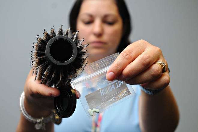 Jarqui Verhauz of Carbon-Monroe-Pike Drug & Alcohol Commission Inc., holds an ordinary hair brush that can be modified to hold drugs Wednesday, July 29, 2015 in a mock ’teenage bedroom’ during a drug forum at the Bucks County Intermediate Unit in Doylestown. State Rep. Marguerite Quinn, R-143, was on hand and took tour of the room seeing many places a teen could hide drugs.