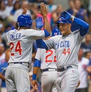 Chicago Cubs' Anthony Rizzo gets a high five from teammate Dexter Fowler after hitting a three run home run off Milwaukee Brewers' Jeremy Jeffress during the eighth inning of a baseball game Thursday, July 30, 2015, in Milwaukee. (AP Photo/Tom Lynn)