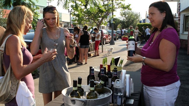 Michele Carreira-Haid, right, talks with Bonnie Branch of Jupiter, left, and Chrysann Sutton of West Palm Beach at her Winehooch.com booth at Northwood Art & Wine Promenade continues to expand its monthly festival which in turn brings people to Northwood. (The Palm Beach Post file)