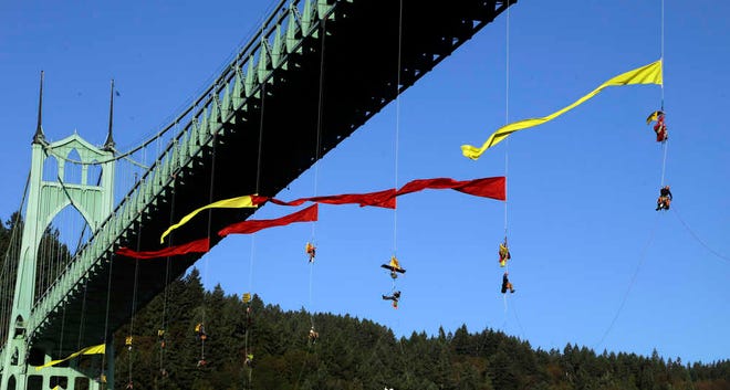 Activists hang from the St. Johns bridge in an effort to block the Royal Dutch Shell PLC icebreaker Fennica from leaving for Alaska in Portland, Ore., Thursday, July 30, 2015. The icebreaker, which is a vital part of Shell's exploration and spill-response plan off Alaska's northwest coast, stopped short of the hanging blockade, turned around and sailed back to a dock at the Port of Portland. (AP Photo/Don Ryan)