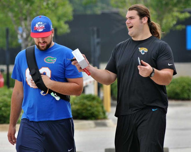 Will.Dickey@jacksonville.com. Jaguars center Luke Bowanko (left) and offensive tackle Austin Pasztor walk out of the stadium after reporting in for training camp Thursday at EverBank Field. (The Florida Times-Union, Will Dickey)