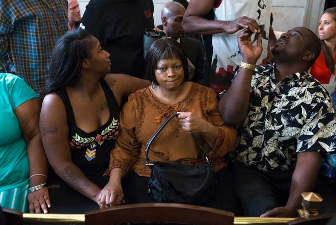 Terina Allen, sister of Samuel DuBose, sits with family members as she reacts in the courtroom following the arraignment of former University of Cincinnati police officer Ray Tensing at Hamilton County Courthouse for the shooting death of motorist DuBose, Thursday, July 30, 2015, in Cincinnati. Tensing, who was indicted and fired from his job on Wednesday, shot and killed Dubose on July 19. Tensing pleaded not guilty to charges of murder and involuntary manslaughter. (AP Photo/John Minchillo)