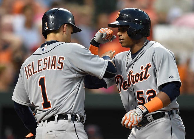 Detroit Tigers' Yoenois Cespedes, right, is congratulated by teammate Jose Iglesias after hitting a two-run home run against the Baltimore Orioles in the fourth inning of a baseball game, Thursday, July 30, 2015, in Baltimore. (AP Photo/Gail Burton)