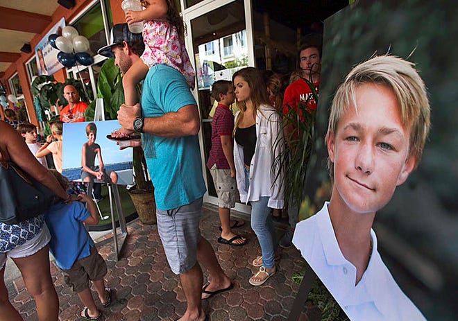 Pictures of Perry Cohen, left, and Austin Stephanos, right, are on display at fundraiser at Jumby Bay Island Grill, Wednesday, July 29, 2015, in Jupiter, Fla., during a fundraiser to pay for private search efforts for Nick Cohen and Austin Stephanos who have been missing since they took their boat out of the Jupiter Inlet Friday. (Richard Graulich/The Palm Beach Post via AP) (Richard Graulich/The Palm Beach Post via AP)