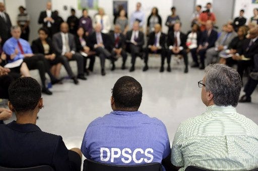 Inmate Terrell Johnson, center, a participant in the Goucher College Prison Education Partnership, sits in a discussion with U.S. Attorney General Loretta Lynch, Education Secretary Arne Duncan and other officials inside the Maryland Correctional Institution-Jessup on Friday in Jessup, Md.
