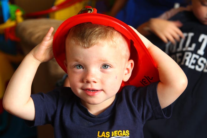 Christopher Dumas, 2, of Quincy, has Cerebral Palsy and a love of firefighters. His mother, Siobhan, has posted to Facebook and the post has gone viral, so fire departments from all over have been sending him t-shirts, hats, and other small gifts, which he enjoys Friday, July 31, 2015.
Gary Higgins/The Patriot Ledger