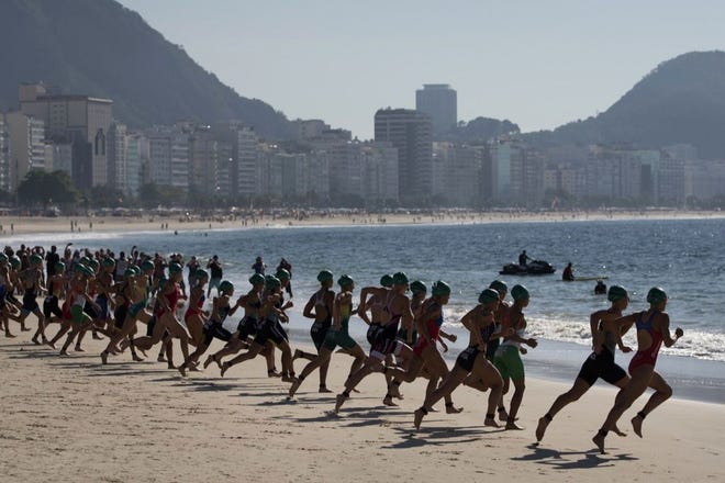 Triathletes run towards the water at the start of the women's triathlon ITU World Olympic Qualification Event in Rio de Janeiro, Brazil on Sunday. The World Olympic Qualification is a test event for the Rio 2016 Olympics.