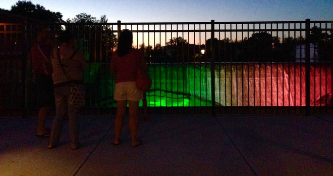 Residents enjoy the first few moments of the new colorful lights at the waterfall at Gateway Park on Friday evening. PHOTO BY SHAWN P. SULLIVAN