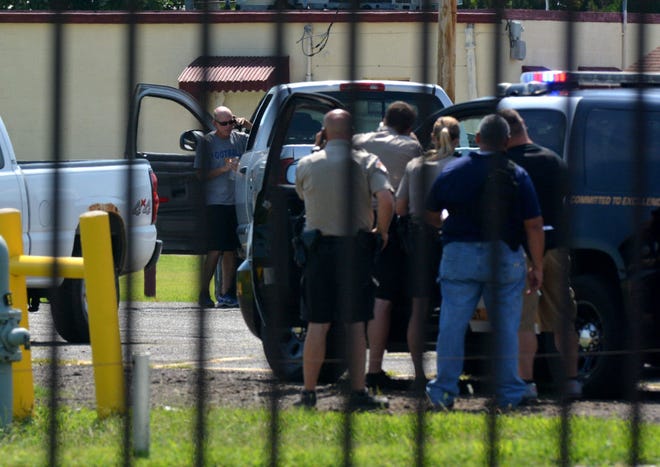 Police officers attempt to negotiate with a man via phone who discharged a firearm and threatened himself with it during a stand-off in the parking lot of the Rusty Needle in Hutchinson on August 2, 2015.
