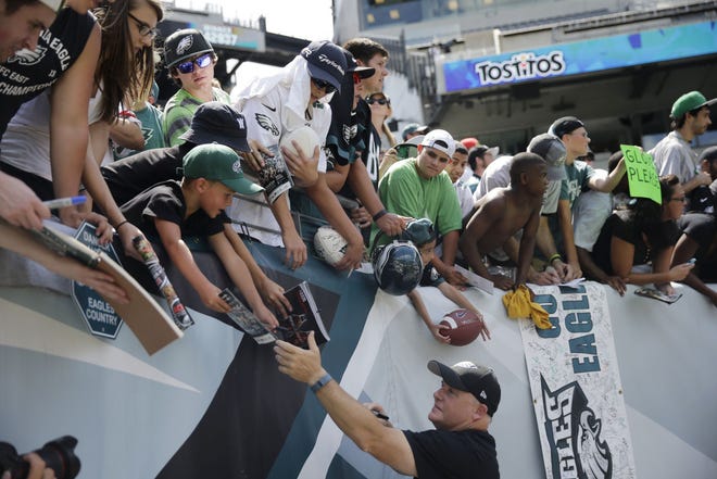 Philadelphia Eagles head coach Chip Kelly signs autographs after practice at NFL football training camp, Tuesday, Aug. 4, 2015, in Philadelphia. (AP Photo/Matt Rourke)