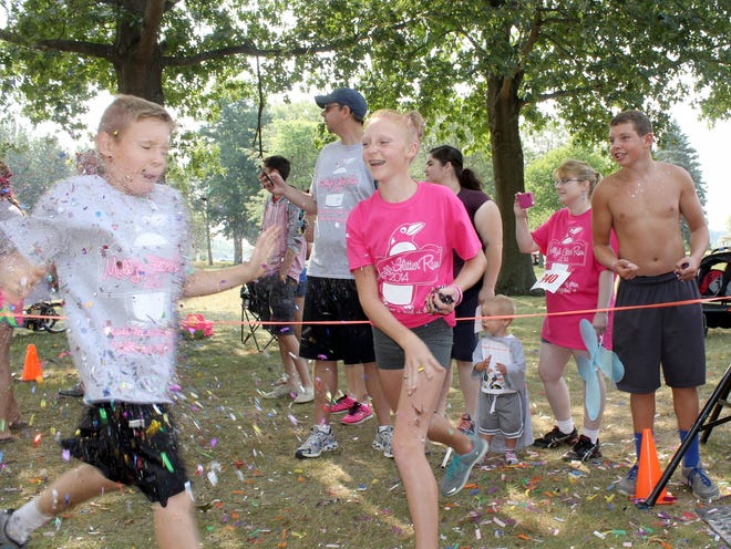 Participants are showered with glitter as they crose the finish line. ANDY BARRAND PHOTO
