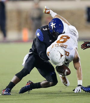 Texas' Jaxon Shipley fumbles the ball after a hit from Texas Tech's J.J. Gaines during their game in Lubbock.