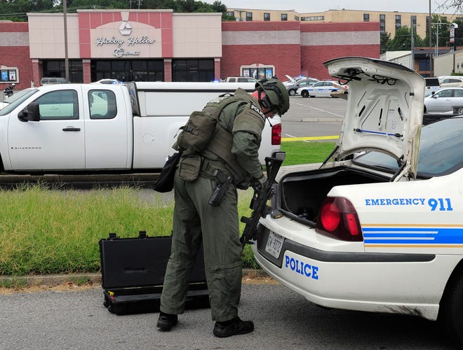 A police officer gathers his tactical gear as he responds to an active shooter call in Nashville, Tenn., Wednesday, Aug. 5, 2015. A suspect wielding a hatchet and a gun inside a Nashville-area movie theater died after exchanging gunshots with a police team that stormed the theater, police said Wednesday. AP PHOTO