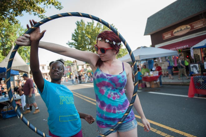 (File) Janiyah Johnson, of Mount Holly, learns how to spin a hula hoop from Dayna Fisher at the festival.