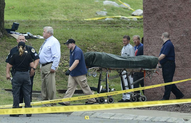 The body of the suspect is removed from a movie theater following a shooting Wednesday, in Antioch, Tenn. A man armed with a hatchet and pellet gun unleashed a volley of pepper spray at audience members inside the movie theater, exchanging fire with a responding officer before being shot dead by a SWAT team as he tried to escape out a back door, police said. AP Photo/Mark Zaleski