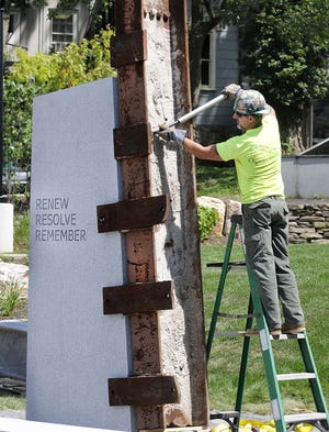 Contractor Tim Verna bolts the steel beam from the destroyed World Trade Center Towers to its base beside the new Doylestown Justice Center. The memorial is being funded by donations to the Travis Manion Foundation.