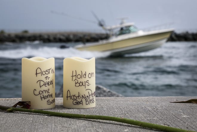 Candles with handwritten messages saying "Come Home Safe" and "Hold on Boys" were seen at Jupiter Inlet in Jupiter, Fla., Sunday, Aug. 2, 2015. After hundreds of rescue workers fanned out across a massive swath of the Atlantic for a full week, the Coast Guard's search for two teenage fishermen ended Friday. Austin Stephanos and Perry Cohen have been missing since July 24, when they took a small boat out of the inlet. (Bruce R. Bennett/Palm Beach Post via AP)