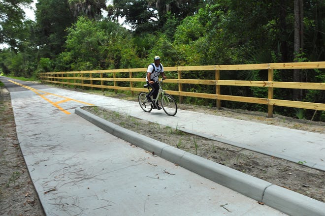 A lone bicyclist heads eastward along a newly completed section of the East Central Regional Rail Trail east of Osteen earlier this month. In coming years, he'll be able to bike to the beach, after the Volusia County Council approved funds for a trail to New Smyrna Beach. News-Journal file/PETER BAUER