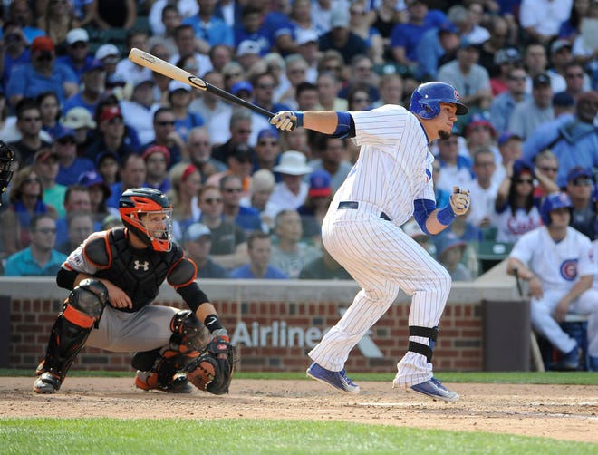 Chicago Cubs' Kyle Schwarber, right, hits a two-RBI single against the San Francisco Giants during the fifth inning of a baseball game, Friday, Aug. 7, 2015, in Chicago. (AP Photo/David Banks)