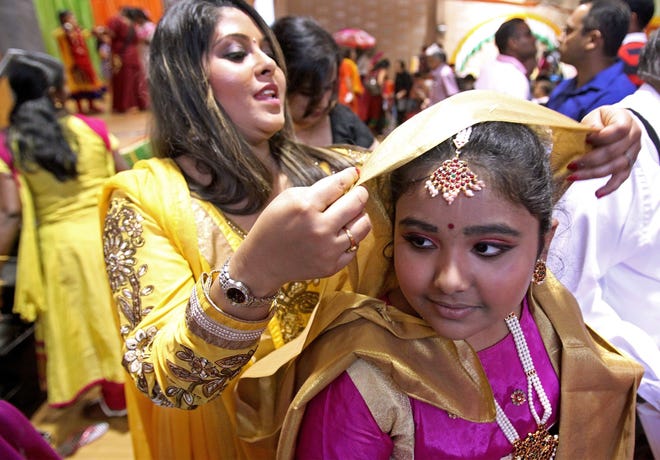 Dance instructor Mona Mitra, left, veils Jessica Pabla, right, as she prepares to perform a traditional "Kathak" dance at a previous India Day celebration. T&G File Photo/Paul Connors