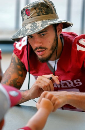 Dallis Todd gives a fist bump to a fan as he signs autographs during Meet the Sooners Day for the University of Oklahoma Sooners (OU) football team at Gaylord Family-Oklahoma Memorial Stadium in Norman, Okla., on Saturday, Aug. 8, 2015. Photo by Steve Sisney, The Oklahoman