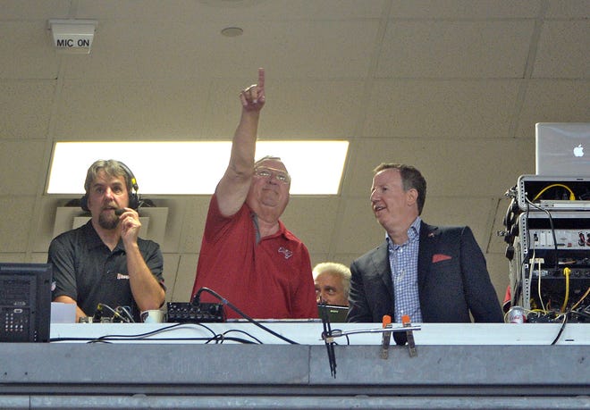 Tampa Bay Buccaneers announcer, Gene Deckerhoff, center, is honored by team Co-Chairman Bryan Glazer, right, for 25-years of calling games during the first quarter of an NFL football game between the Tampa Bay Buccaneers and the New Orleans Saints Sunday, Sept. 15, 2013, in Tampa, Fla.