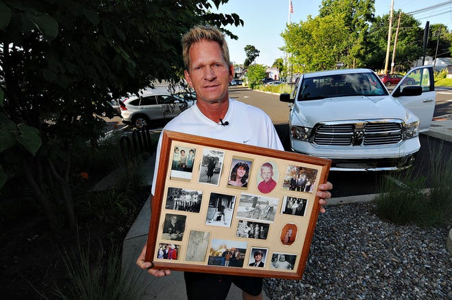 Edmund Nelson holds family images at the SEPTA parking lot in Hatboro where is house once stood. Nelson is seeking information and closure regarding the 1971 hit-and-run death of his grandmother, Alvina Dale, by the Hatboro Train Station.