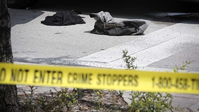 Clothing lies on the road beside a Toyota Camry belonging to a shooting victim at the intersection of Lucerne Avenue and North G Street in Lake Worth Sunday, August 9, 2015. The victim drove himself to the police station there after being shot on Washington Avenue, PBSO reports. (Bruce R. Bennett / The Palm Beach Post)